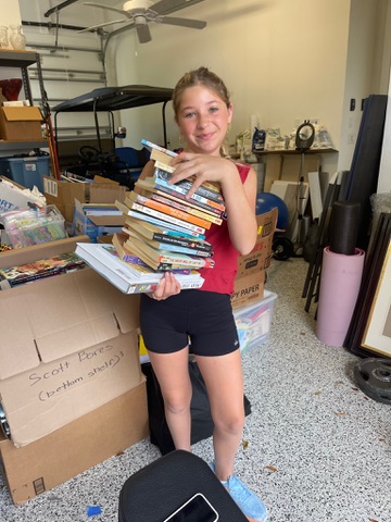 Carrying a stack of books to donate